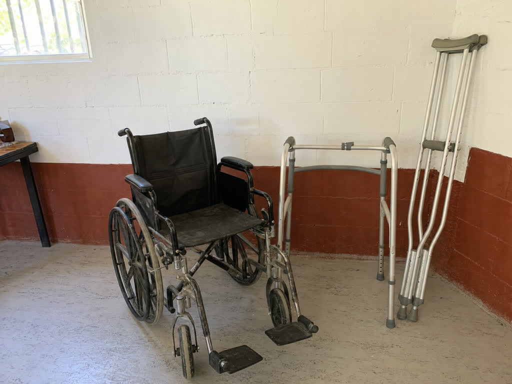 Silla de ruedas, andador y bastones dispuestos en una sede social